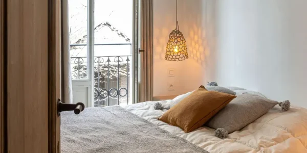 Slaapkamer 2 met een zalig dubbel bed, en-suite badkamer en zicht op de kerk van Blankenberge.